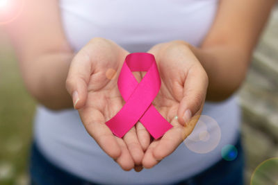 Femme en surpoids et tenant le ruban rose symbole du cancer du sein